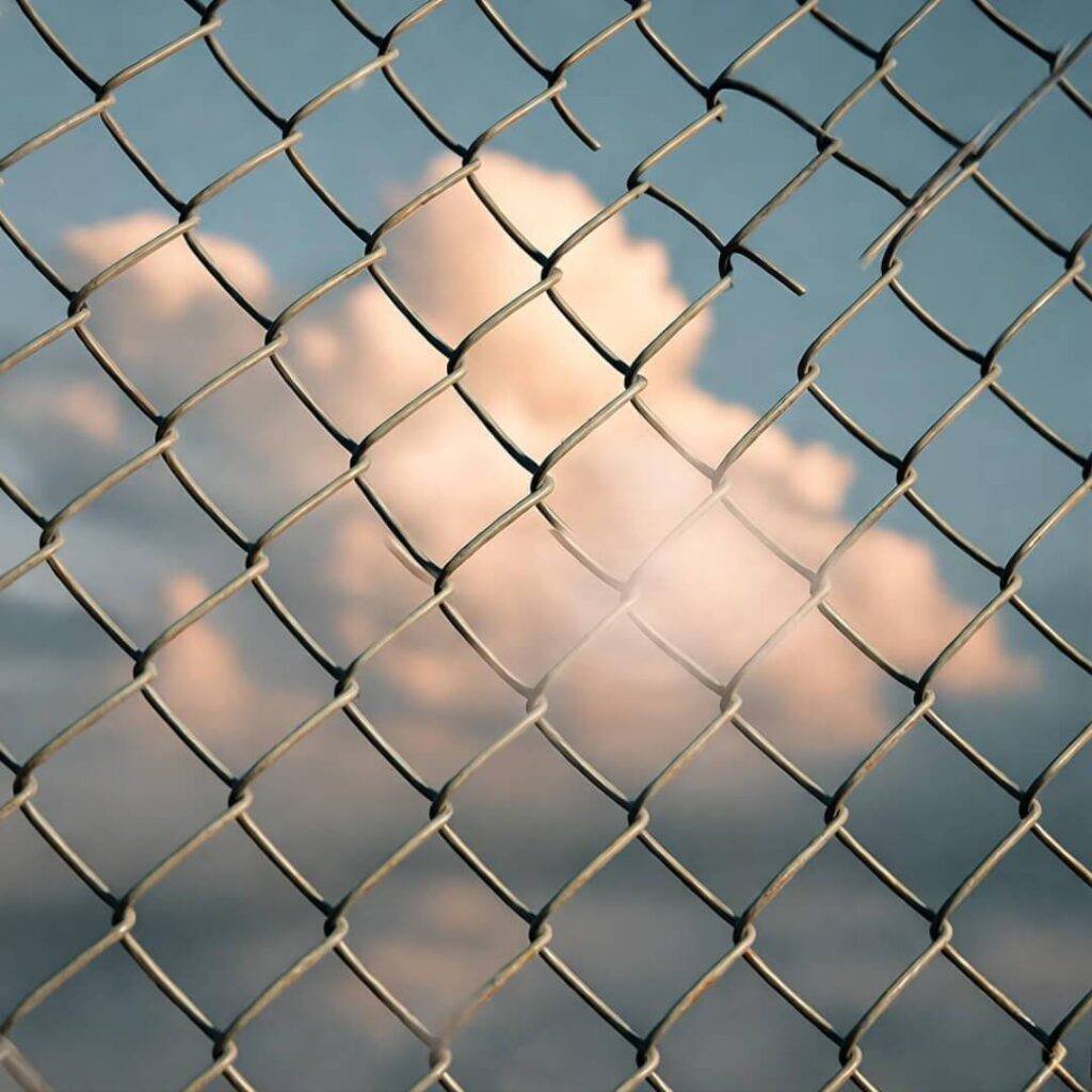 Fence trapping glowing cloud, tilted shot.